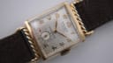 Detailed close-up of the curved crystal and dial text, showing reflections.