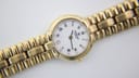 Close-up of gold Raymond Weil 9954 dial with white face, Roman numerals, and diamond markers.