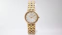Full front view of the petite gold tone Tissot 329-S325 watch with integrated link bracelet on a white background.
