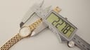 Digital caliper measuring the case diameter of the Tissot watch at 22.18mm.