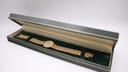 Tissot watch displayed open in a generic green presentation box.
