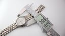 Close-up showing a digital caliper measuring the case diameter of the Tissot T660 titanium watch, displaying a reading of 38.16mm.
