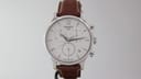 Front view of the Tissot T063617A chronograph watch with white dial, silver case, and brown leather strap.
