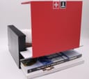 The open Tissot box revealing an instruction manual or 'The story of a watch company' booklet within a hidden compartment.