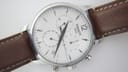 Close-up of the Tissot white chronograph dial with applied baton indices, arabic '12', and three sub-dials.