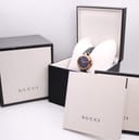 The Gucci 141.4 watch displayed with its original Gucci presentation box and accompanying papers.