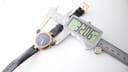 Digital caliper measuring the case diameter of the Gucci watch, showing a precise reading of 32.06mm.