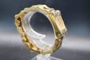 Back-right three-quarter view of the Gucci 2305L integrated bracelet, highlighting the brushed and polished finishing and plating wear on link edges.
