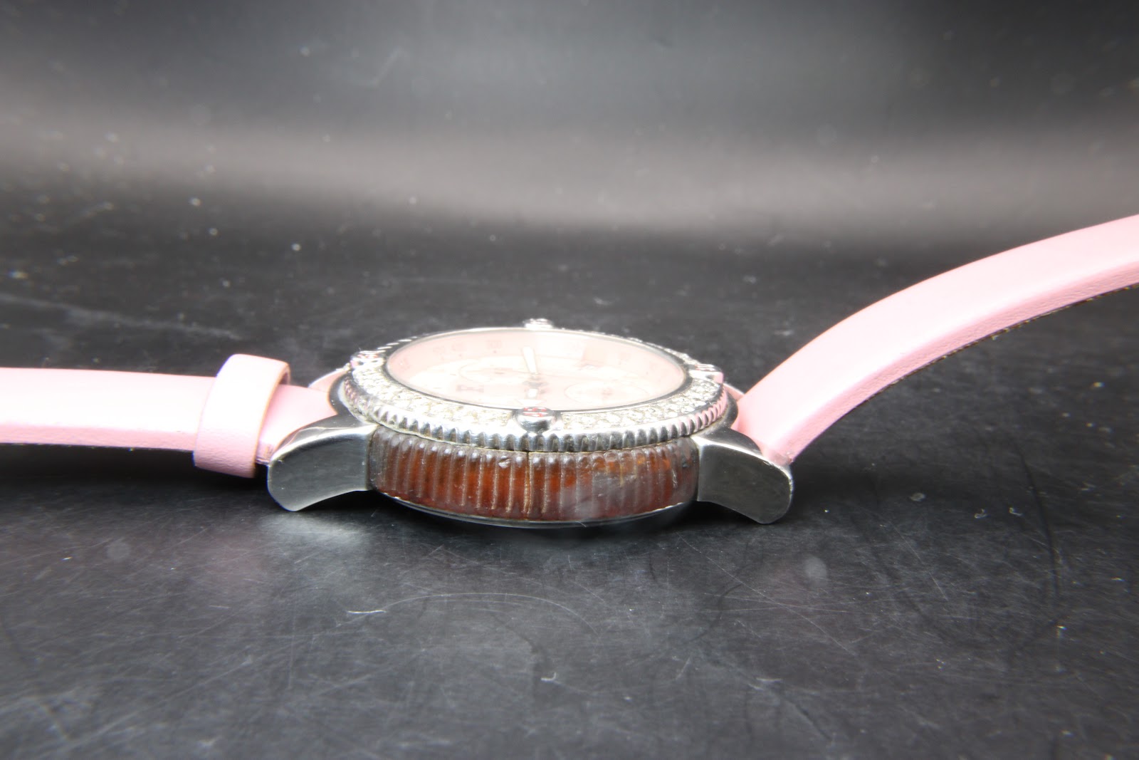 Opposite side view of the watch case, showing the textured brown mid-case and lug design.