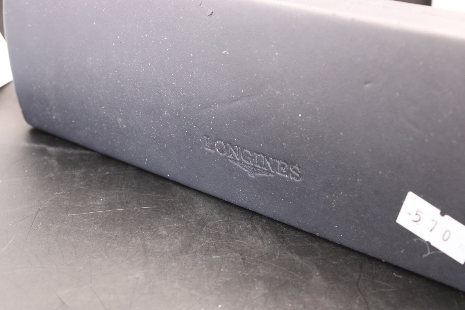 Close-up of the embossed 'Longines' logo on the exterior of the original blue Longines presentation box.