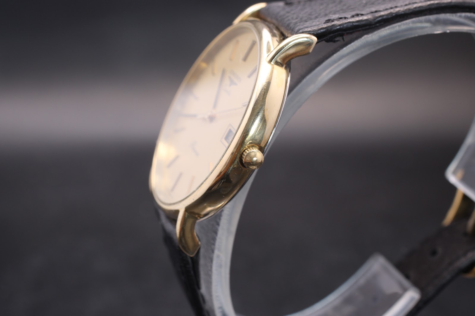 Side profile view of the Longines Présence watch, highlighting its ultra-slim gold-tone case and crown.