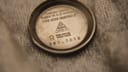 Close-up of the inside of the Omega stainless steel case back, showing "PLAQUE OR G 20 MICRONS" and serial number 562.0018.