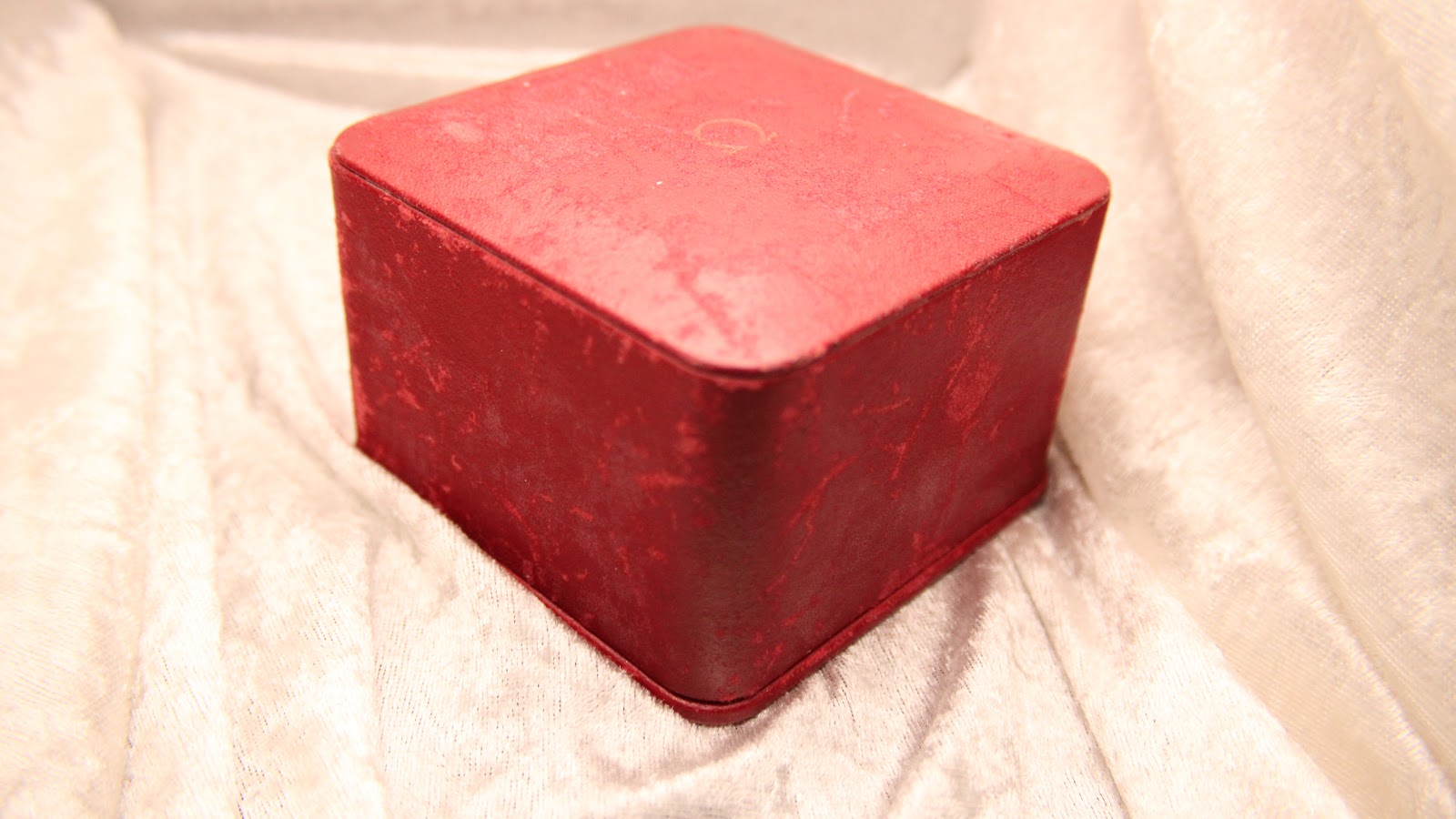 Top view of the closed rectangular red Omega presentation box.