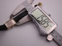 Digital caliper measuring the width of the Omega Geneve watch case at 15.85 mm.