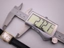 Digital caliper measuring the length of the Omega Geneve watch case at 27.21 mm.