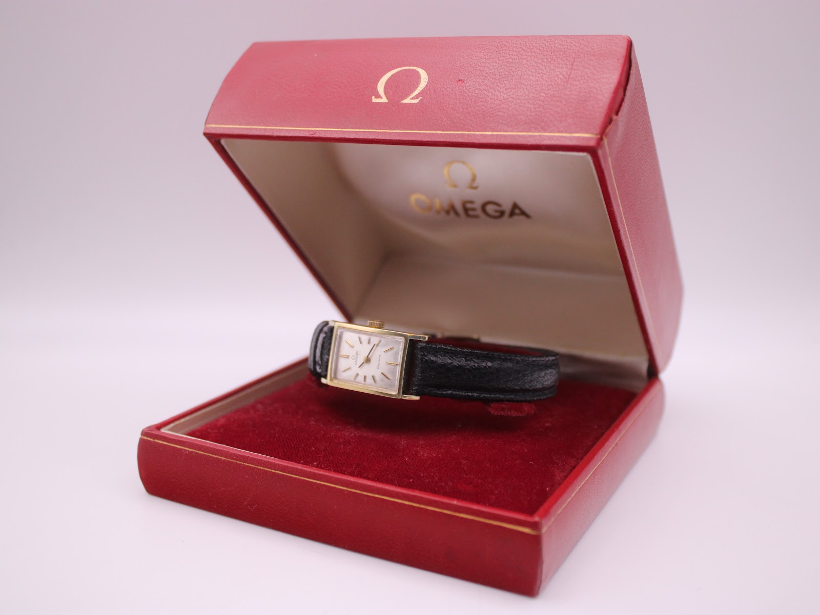 The Omega Geneve watch presented open in its original red Omega box.