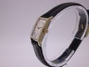 Side view of the Omega Geneve watch showing the fluted crown and gold plated case.