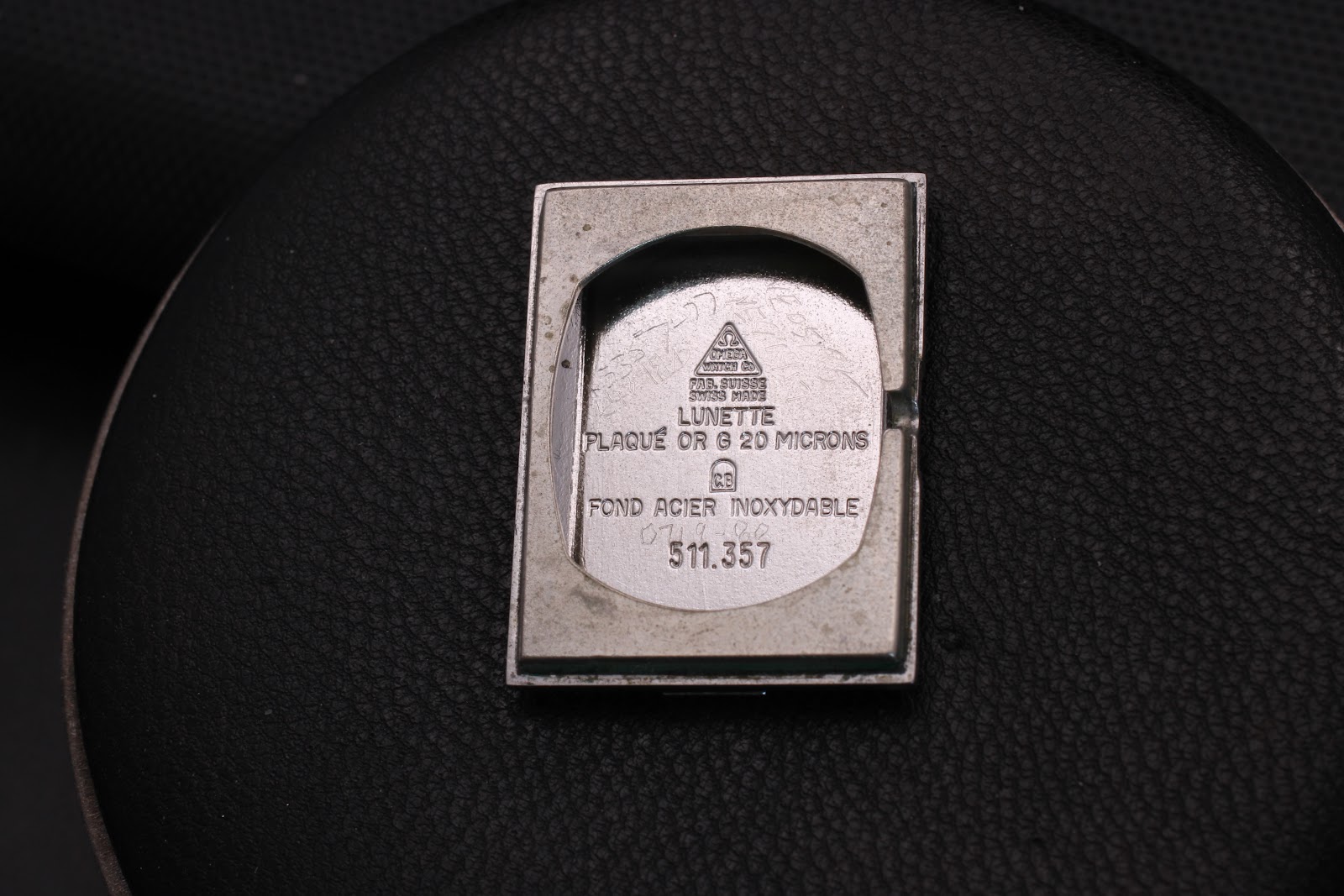 Interior view of the watch case back, showing 'Plaqué Or G 20 Microns' and 'Fond Acier Inoxydable 511.357' engravings.