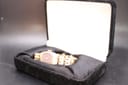 The gold-tone Seiko watch resting in an open black velvet watch box.