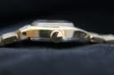 Side view of the watch crown on the right, showing its textured gold finish and case profile.