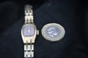 Top-down view of the watch alongside a British one pound coin for size comparison.