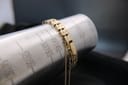 The watch bracelet wrapped around a wrist sizing gauge, indicating a wrist fit of approximately 145mm / 14.5cm.
