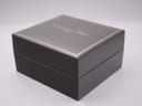 Exterior view of the closed original Christian Dior watch box in black with gold lettering and trim.
