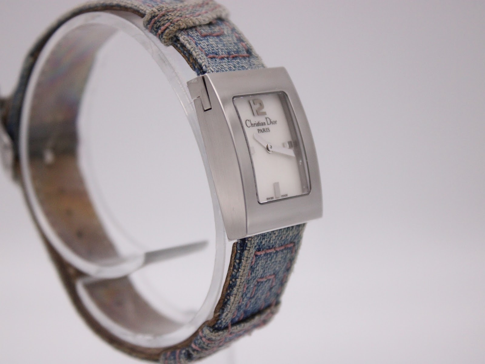 Another side profile view of the Christian Dior D78-109 watch, focusing on the case curves and the texture of the denim-style strap.