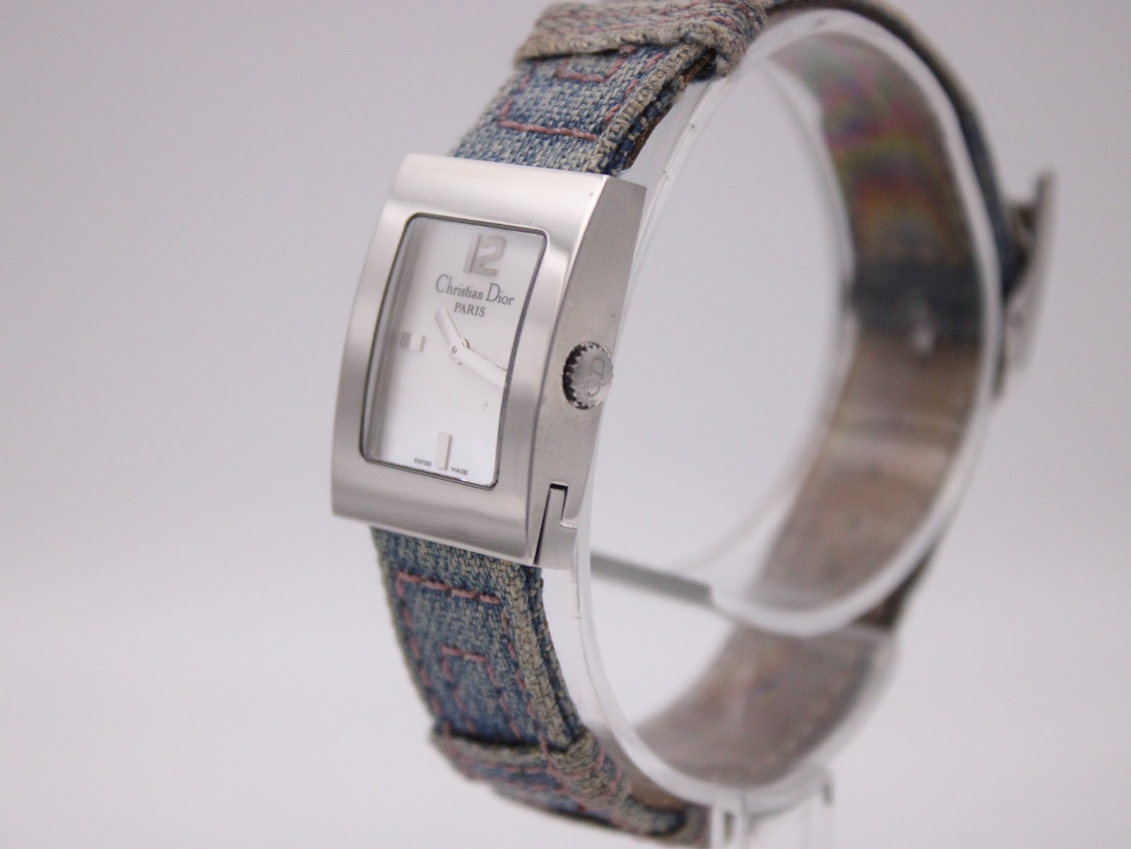 Side profile view of the Christian Dior D78-109 watch, showing the polished case and crown detail, with the blue fabric strap.