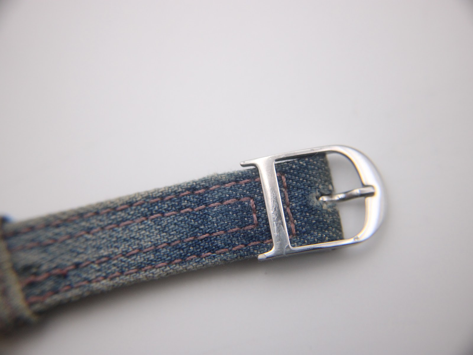 Close-up of the polished silver-tone buckle, clearly showing the engraved 'D' Christian Dior logo.