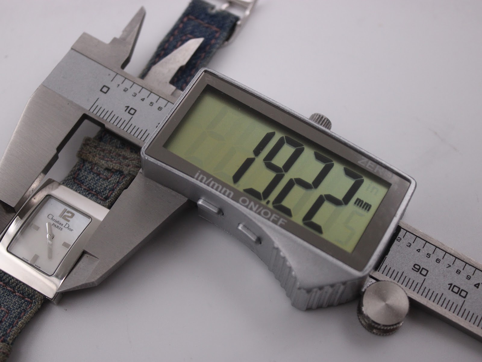 Digital caliper measuring the case width of the Christian Dior D78-109 watch, displaying a precise reading of 19.22mm.