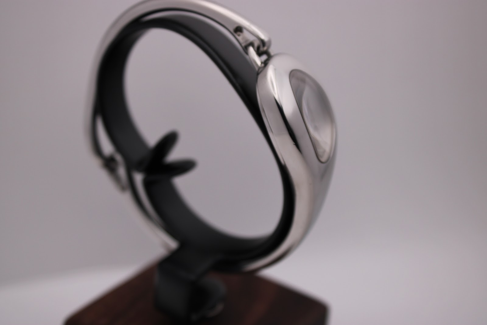 Opposite side view of the Gucci 103 watch on a stand, showcasing the sleek, integrated bangle design.