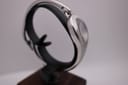 Opposite side view of the Gucci 103 watch on a stand, showcasing the sleek, integrated bangle design.