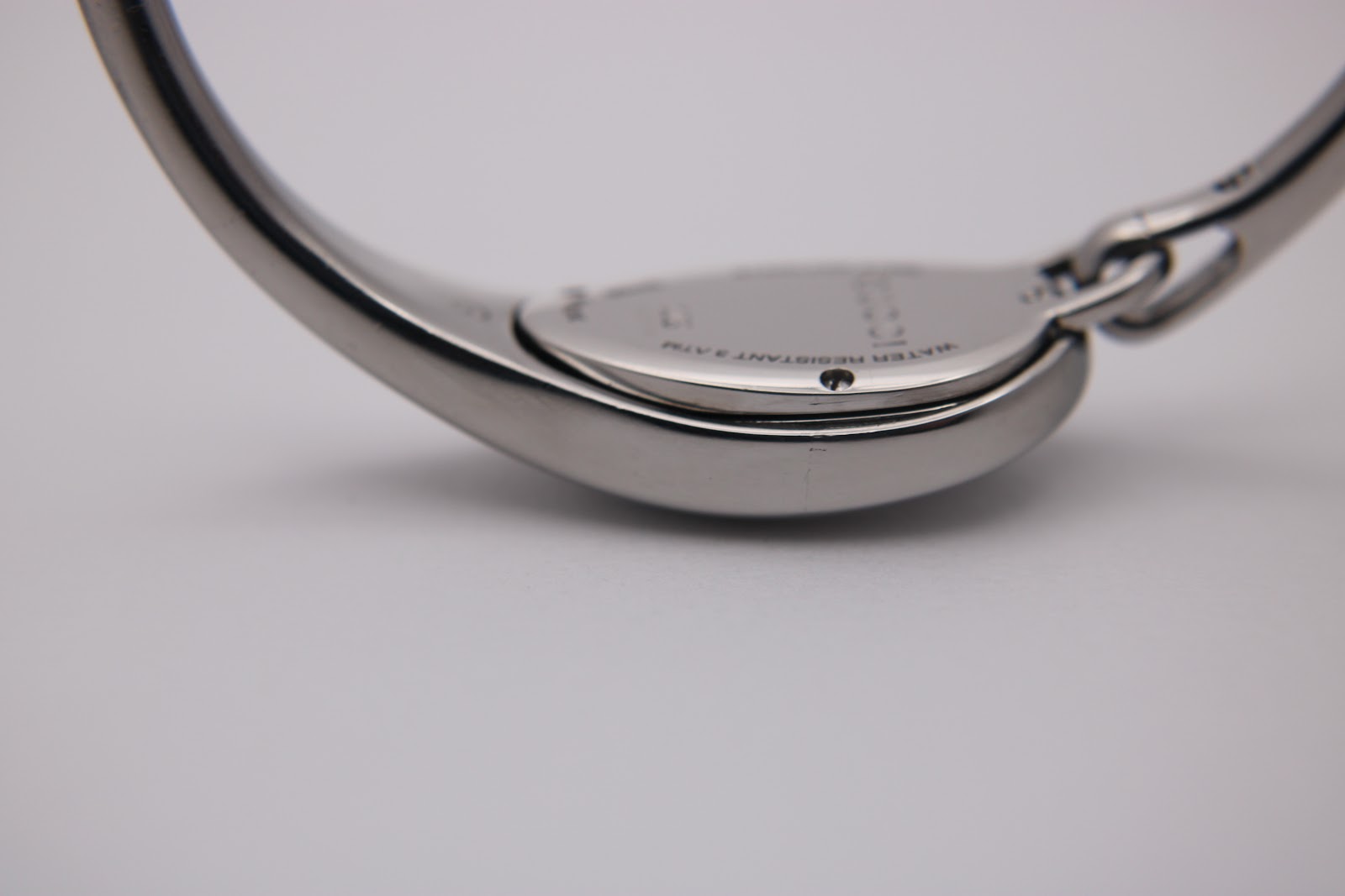 Close-up of the watch's left side, showing the smooth, polished stainless steel case and bangle curves.