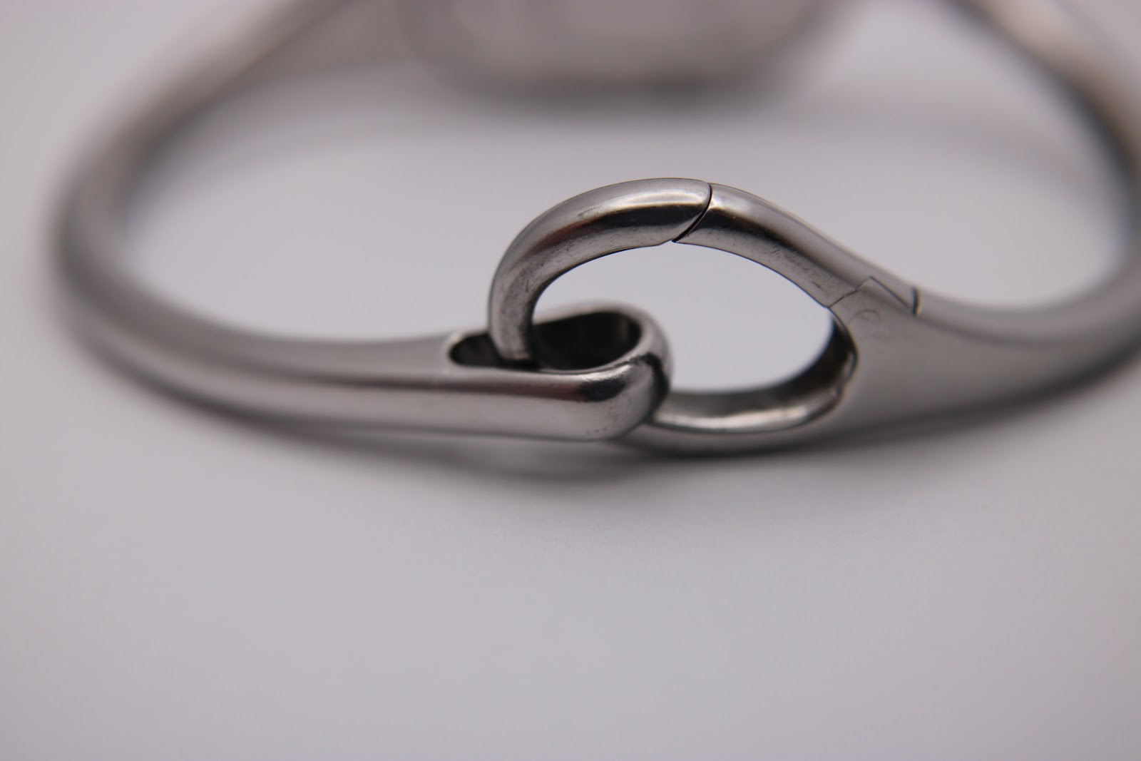 Close-up of the articulated hinge mechanism of the stainless steel bangle bracelet.