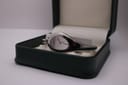Angled view of the Gucci 103 watch resting inside a dark green presentation box with white interior.