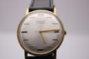 Straight front view of the Magna 21 jewels watch dial, highlighting the silver sunburst finish, gold baton indices, and date window at 3 o'clock.
