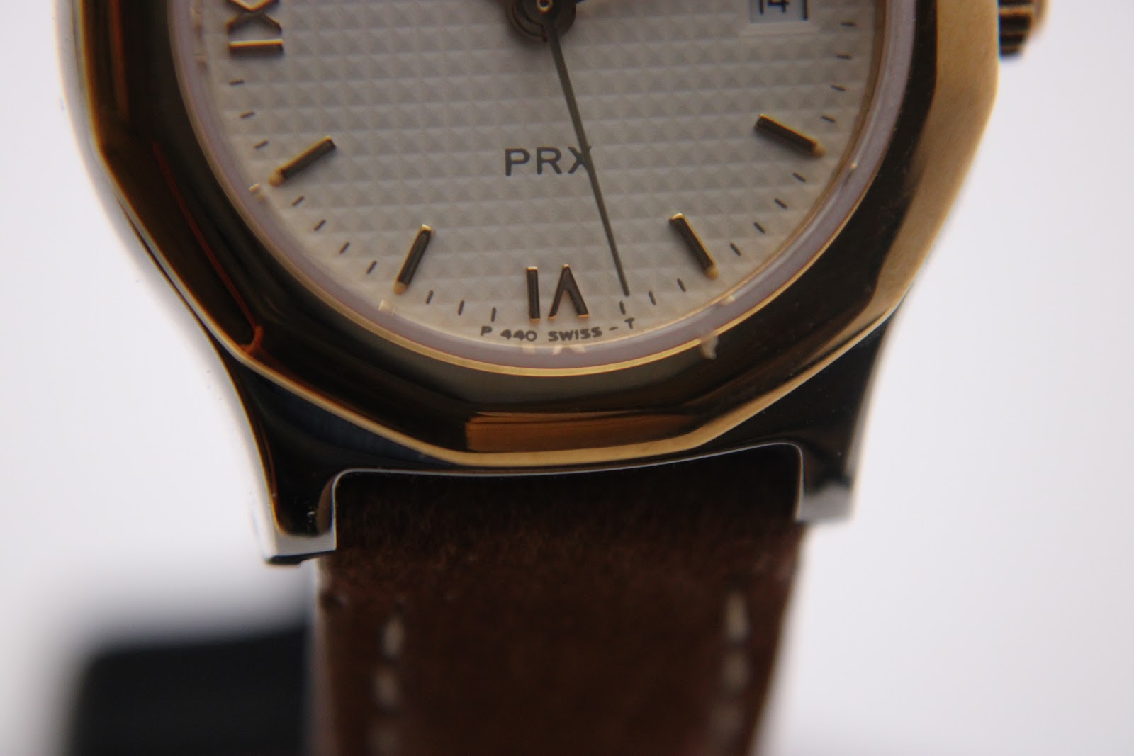 Macro close-up of the bottom part of the Tissot PRX dial, revealing 'PRX' and 'P 440 SWISS-T' markings.