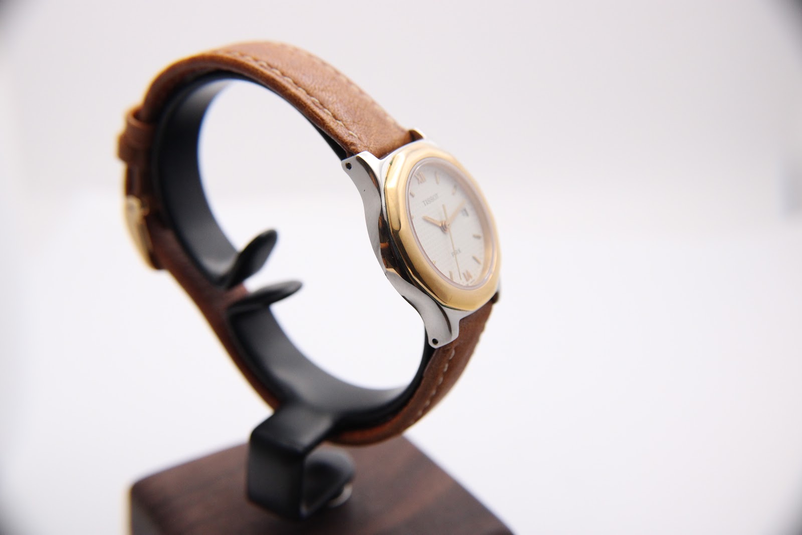 Left-side profile view of the Tissot PRX P340-G on a stand, showcasing the sleek two-tone case design.