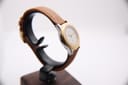 Left-side profile view of the Tissot PRX P340-G on a stand, showcasing the sleek two-tone case design.