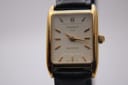 Close-up front view of the Tissot T815 Fascination watch, showcasing its white dial with applied gold baton indices.