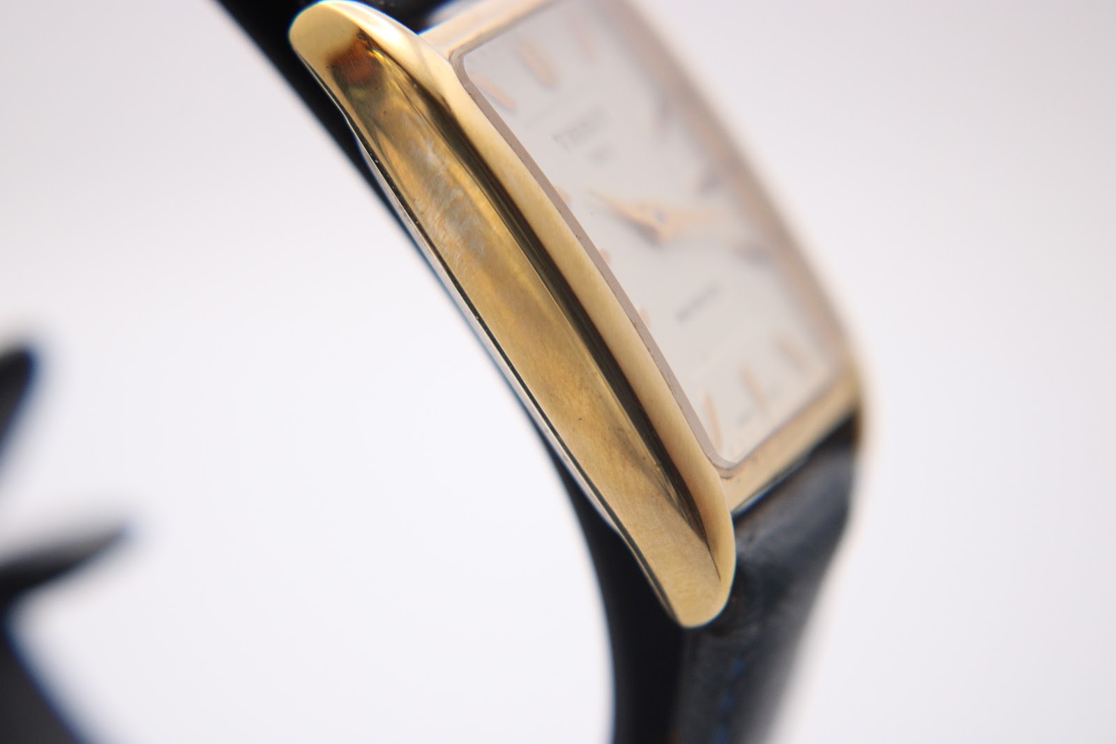 Detailed view of the polished gold-tone rectangular case side of the Tissot Fascination watch.