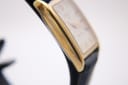 Detailed view of the polished gold-tone rectangular case side of the Tissot Fascination watch.