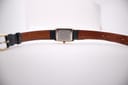 Overhead view of the Tissot watch with the navy leather strap unbuckled, showing inner strap markings 'Darlena' and '14 Anti-Allergy Leather'.