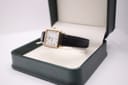 The Raymond Weil 5748 watch displayed on a stand inside an open dark green presentation box, highlighting the watch's design.