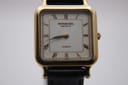 Close-up, front view of the Raymond Weil Genève 5748 dial, showing "RAYMOND WEIL GENEVE" and "QUARTZ" text, brown Roman numerals, and gold-tone hands.