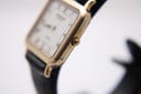 Close-up side view of the Raymond Weil 5748 watch case, highlighting the gold electroplated finish and the signed crown.