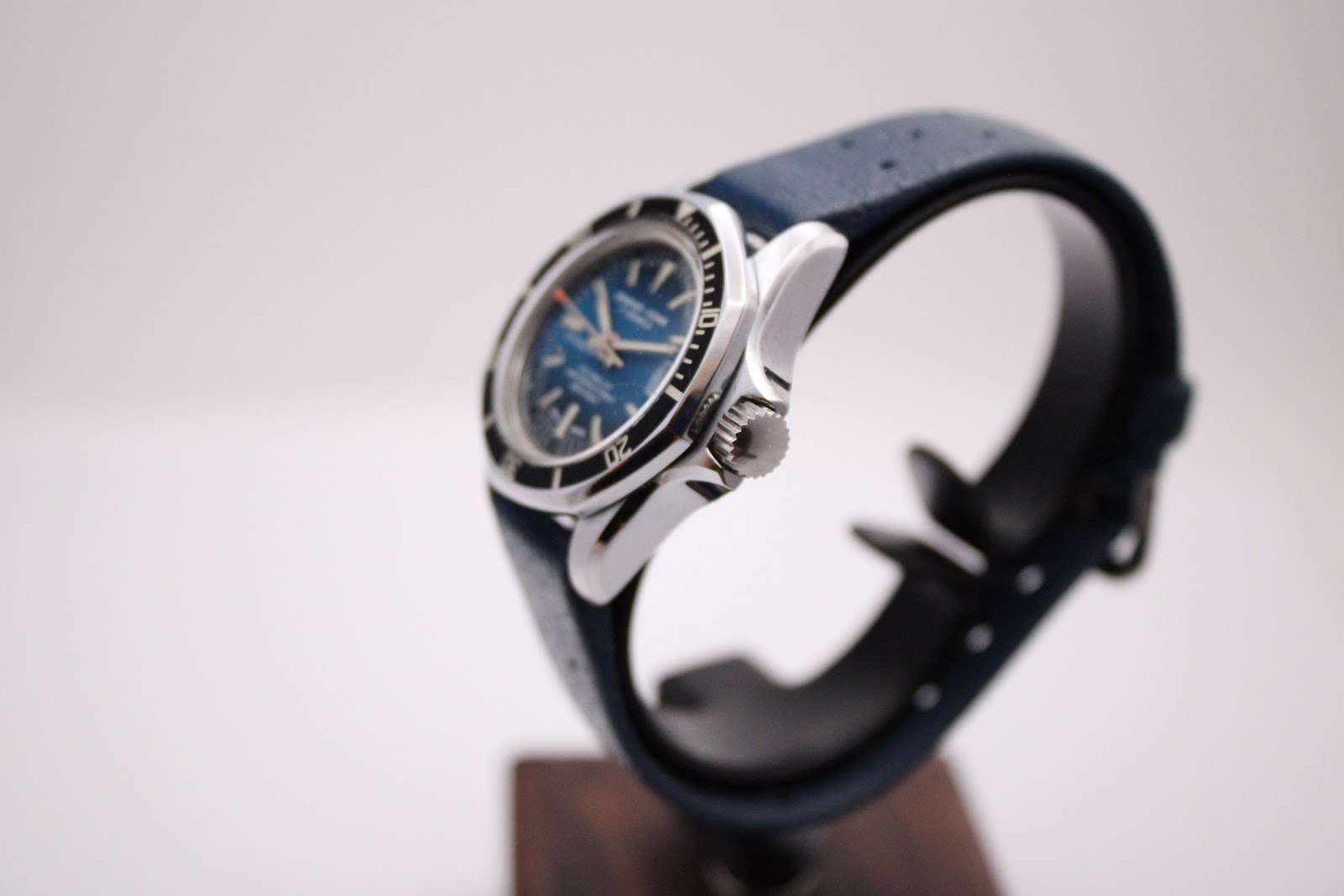 Side profile of the Marine Star watch on a dark display stand, highlighting the polished stainless steel case and crown.