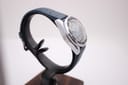 Another angled side view of the Marine Star watch on a stand, showing the case lugs and the textured dark blue rubber strap.