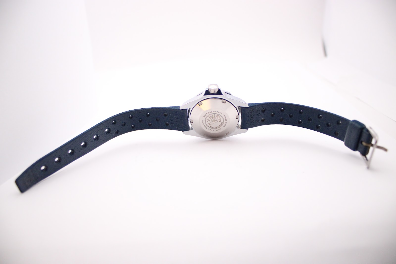 Overhead view of the Marine Star watch with its dark blue rubber strap extended, showing the full length and simple buckle.